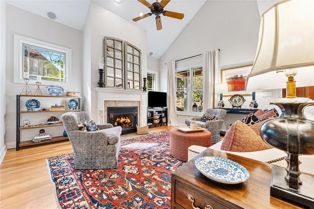 living room featuring high vaulted ceiling, ceiling fan, and light wood-type flooring