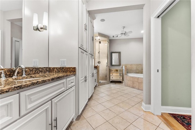 bathroom featuring ceiling fan, vanity, plus walk in shower, and tile patterned flooring