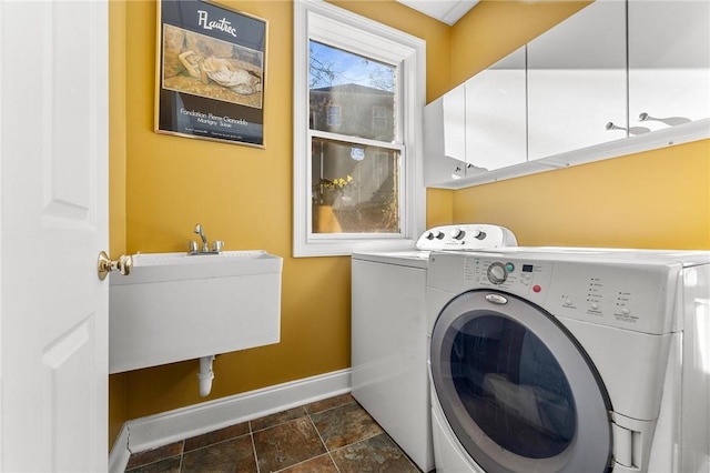 washroom featuring cabinets, sink, and washer and clothes dryer