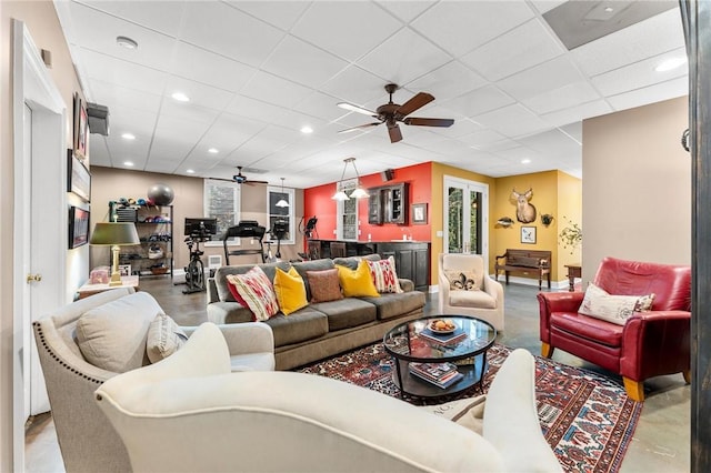 living room featuring a drop ceiling and ceiling fan