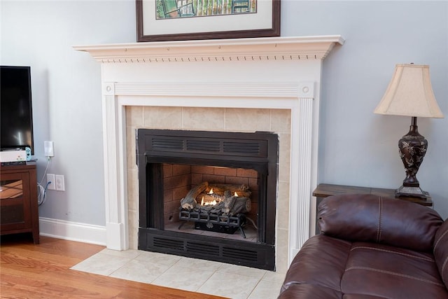 interior details featuring a tiled fireplace and hardwood / wood-style floors