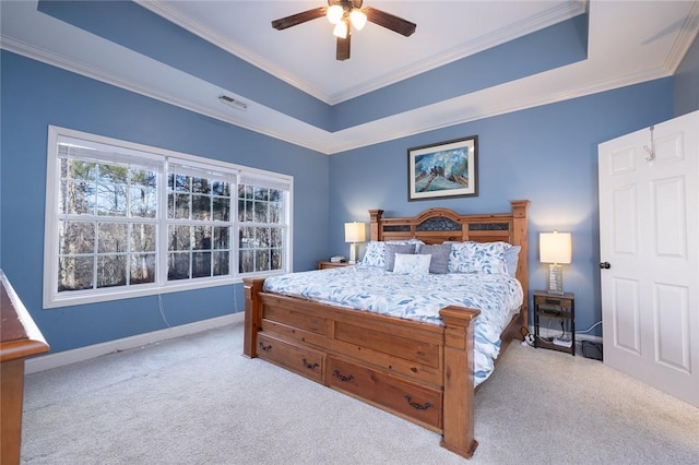 bedroom featuring light carpet, a tray ceiling, and ornamental molding