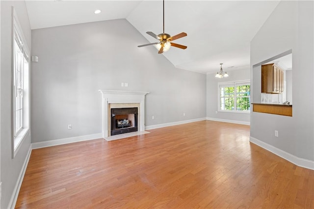 115 Cove View Ct, Seneca, SC 29678 - unfurnished living room with baseboards, high vaulted ceiling, a fireplace with flush hearth, light wood finished floors, and ceiling fan with notable chandelier
