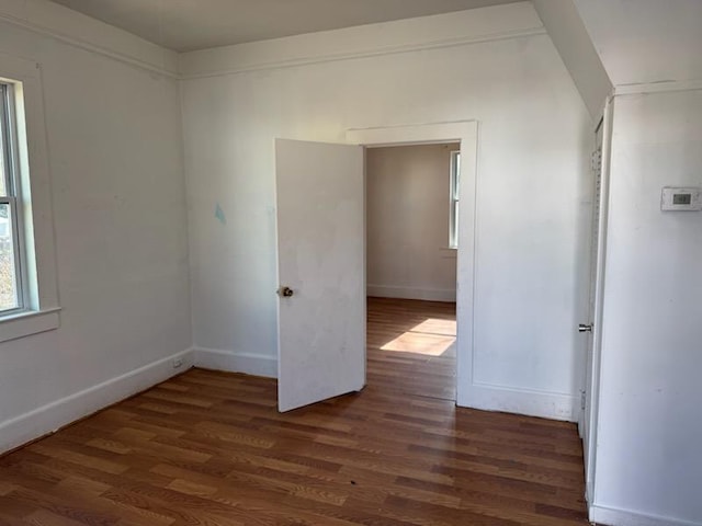 unfurnished room with dark hardwood / wood-style flooring