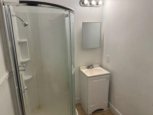 bathroom featuring vanity, wood-type flooring, and walk in shower