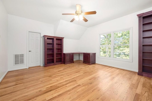 interior space with light wood-style floors, visible vents, vaulted ceiling, and baseboards