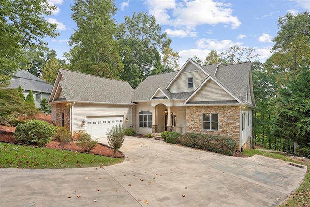 view of front of home with a garage, stone siding, roof with shingles, and driveway