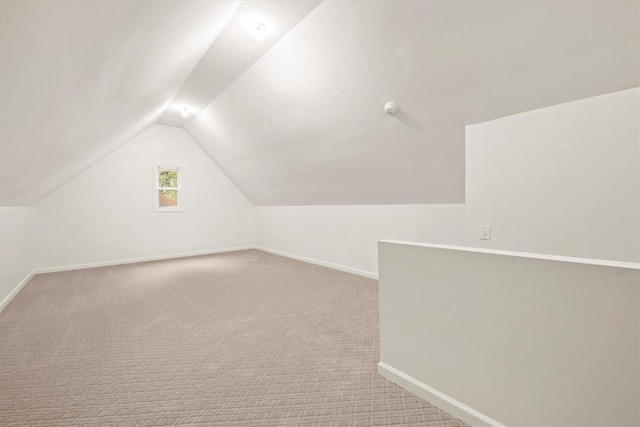 additional living space with lofted ceiling, carpet flooring, and baseboards