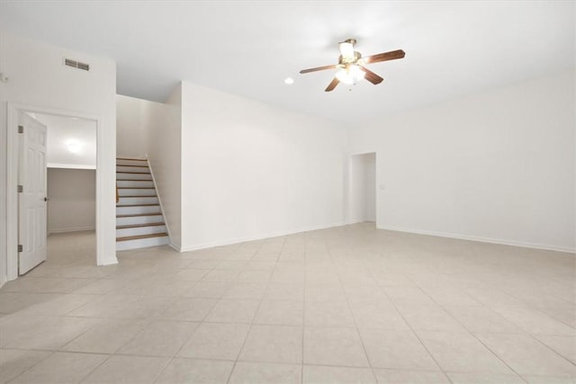 unfurnished living room featuring visible vents, stairway, a ceiling fan, and baseboards