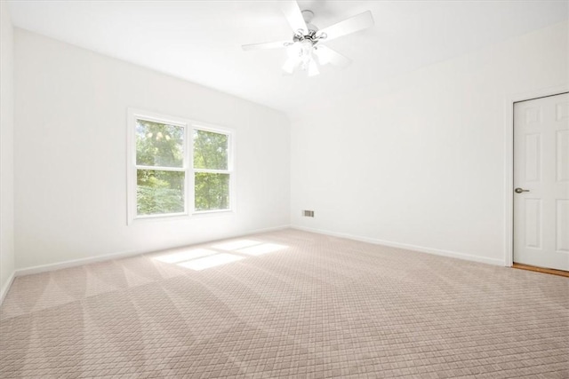 carpeted spare room with visible vents, a ceiling fan, and baseboards