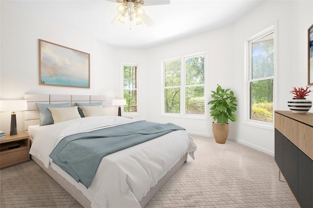 bedroom featuring a ceiling fan, light carpet, and baseboards