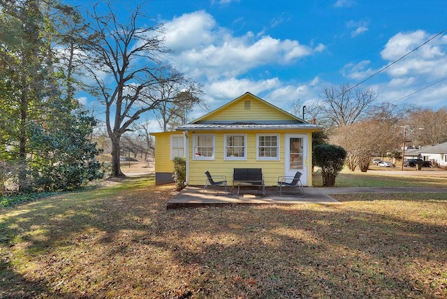 rear view of house with a yard and a patio area