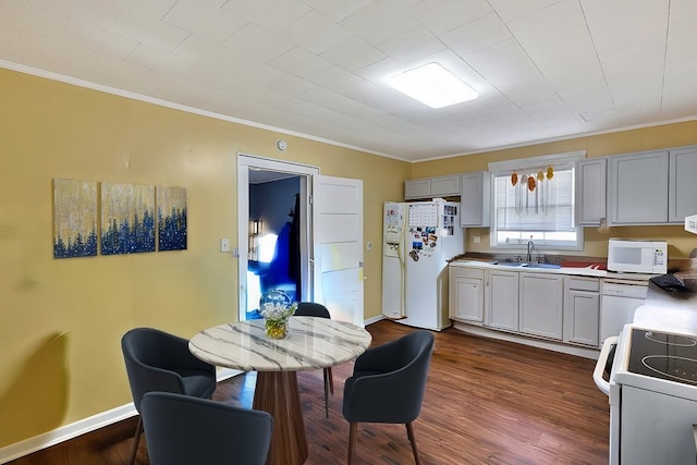 kitchen featuring white appliances, ornamental molding, dark hardwood / wood-style floors, and sink