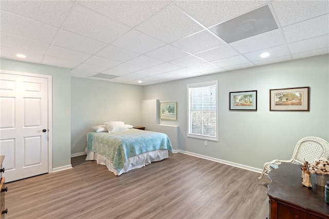 bedroom featuring hardwood / wood-style floors and a drop ceiling