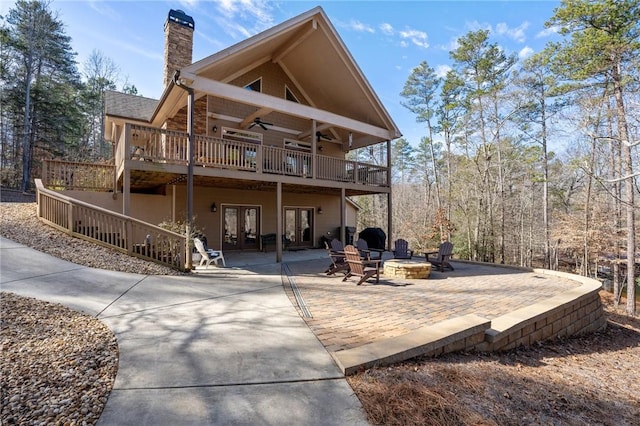 rear view of property featuring a patio, a wooden deck, ceiling fan, and an outdoor fire pit