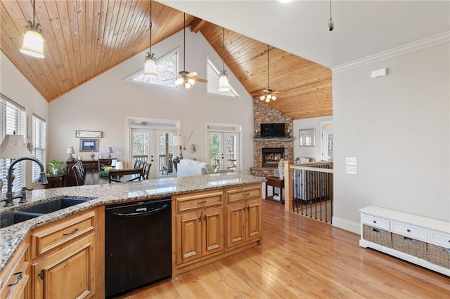 kitchen featuring a stone fireplace, black dishwasher, sink, hanging light fixtures, and french doors