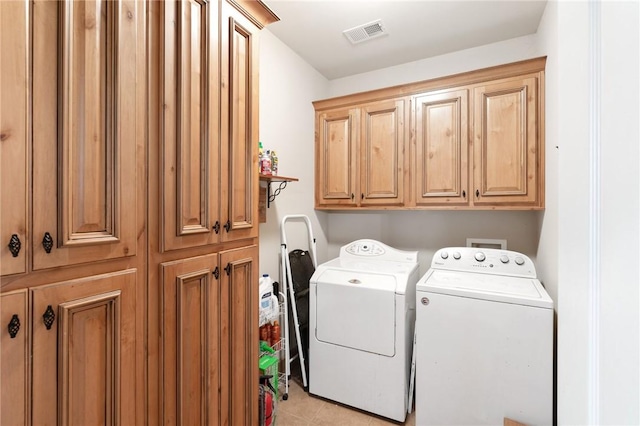 laundry room featuring washer and clothes dryer and cabinets