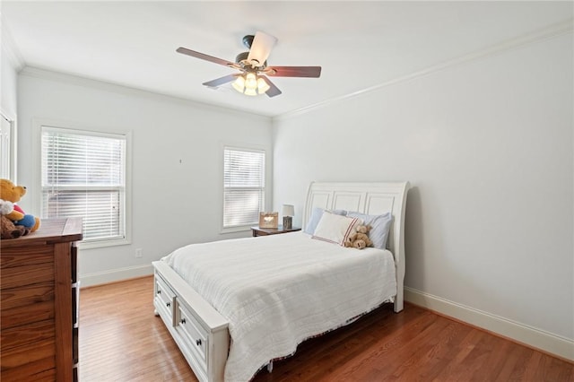 bedroom featuring ceiling fan, ornamental molding, and wood-type flooring