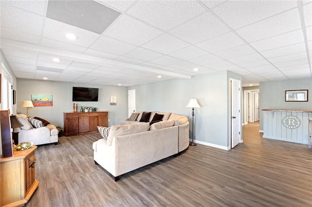 living room with wood-type flooring and a paneled ceiling