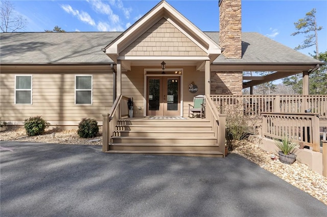 view of front facade featuring french doors, ceiling fan, and covered porch