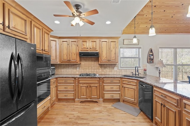 kitchen featuring pendant lighting, sink, stone counters, tasteful backsplash, and black appliances