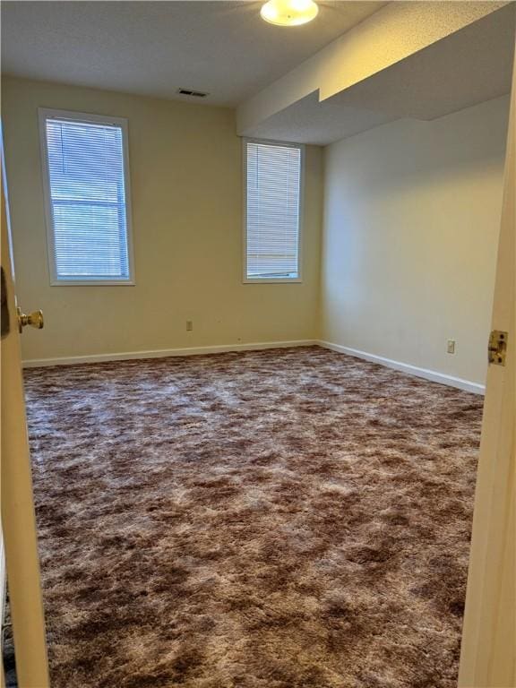 unfurnished room featuring dark colored carpet