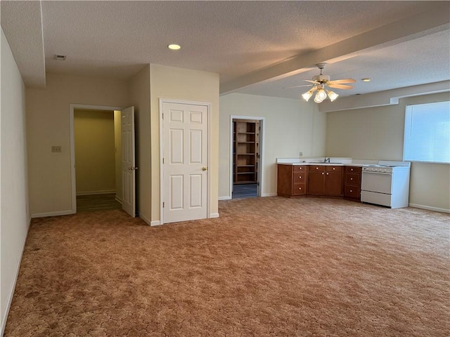 unfurnished living room with ceiling fan, carpet floors, and a textured ceiling