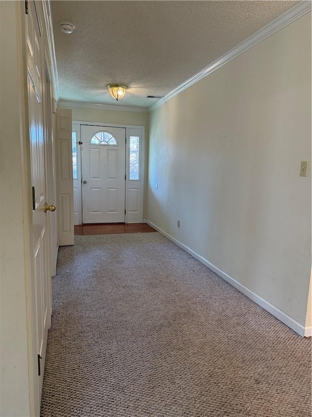 foyer with crown molding, a textured ceiling, and carpet flooring