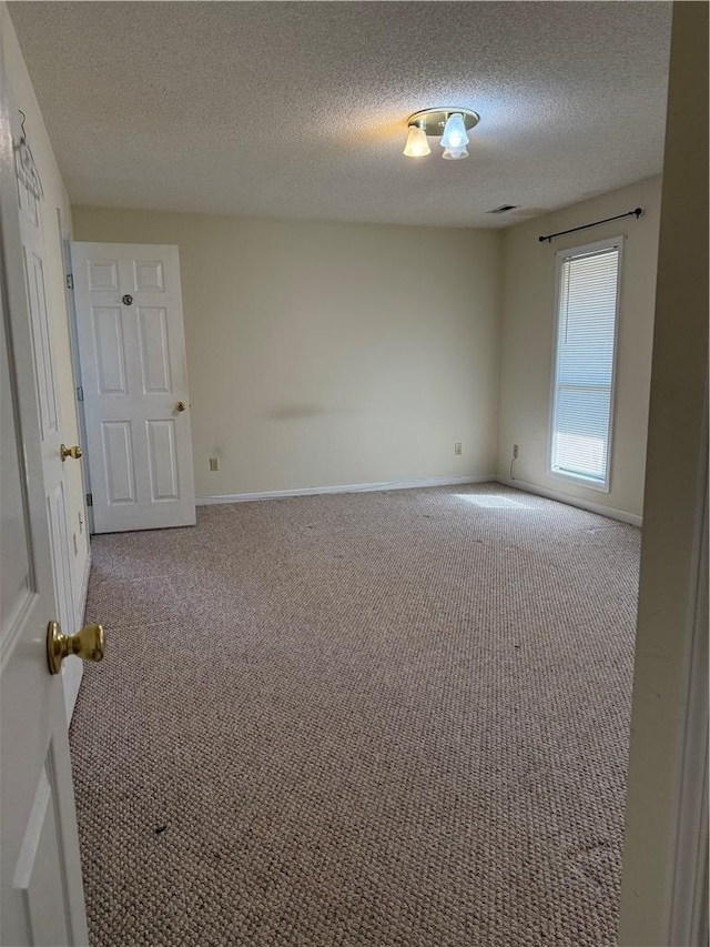 unfurnished room with a textured ceiling and carpet flooring