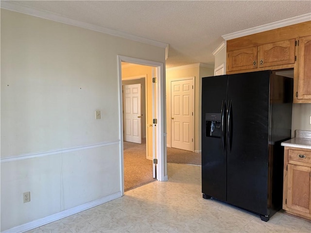 kitchen with crown molding and black fridge with ice dispenser