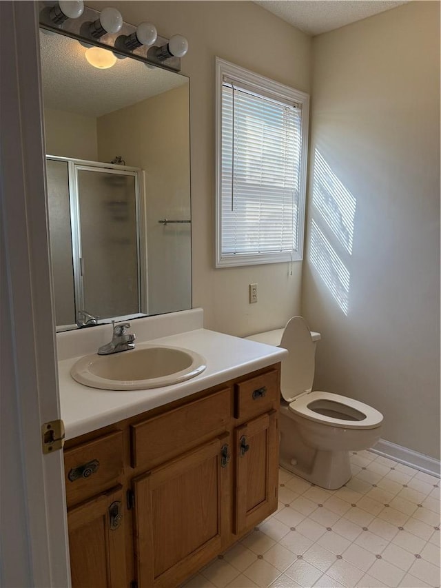 bathroom featuring a shower with door, vanity, a textured ceiling, and toilet