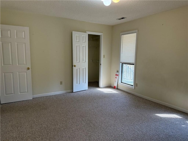 carpeted spare room with a textured ceiling