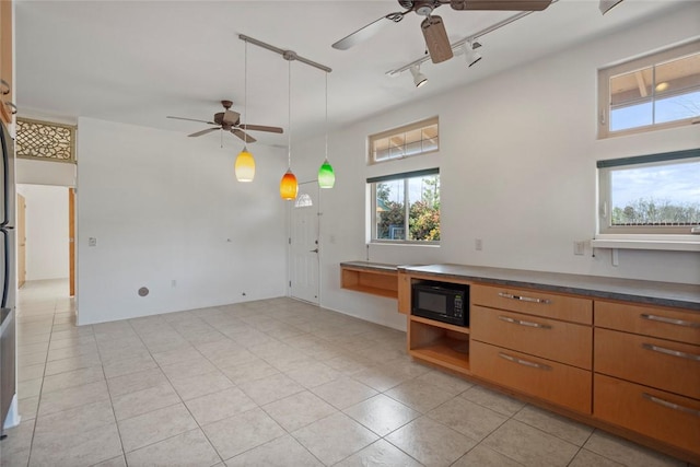 kitchen featuring light tile patterned floors, ceiling fan, black microwave, track lighting, and decorative light fixtures