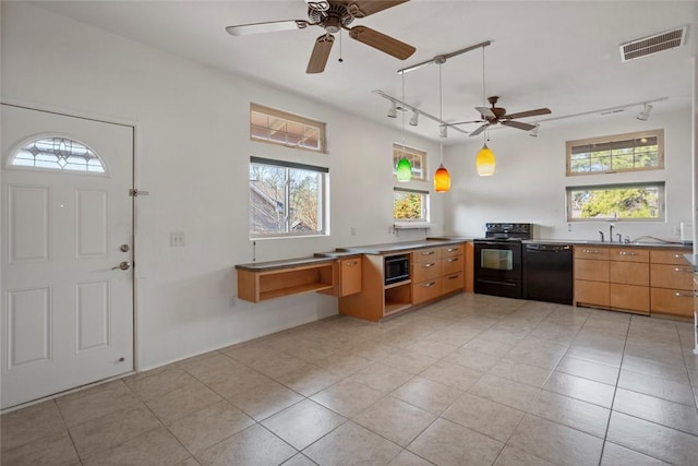 kitchen featuring light tile patterned flooring, pendant lighting, track lighting, and black appliances