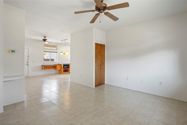 empty room with ceiling fan and light tile patterned flooring