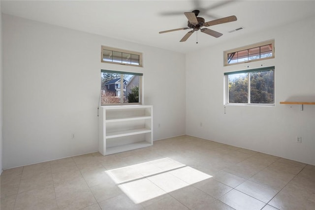 spare room with ceiling fan and light tile patterned floors