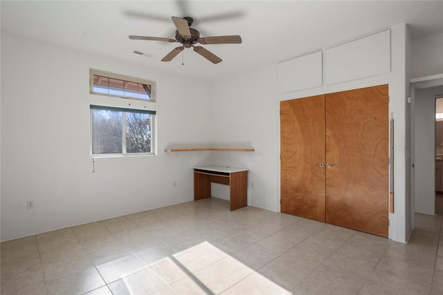 unfurnished bedroom featuring ceiling fan and a closet