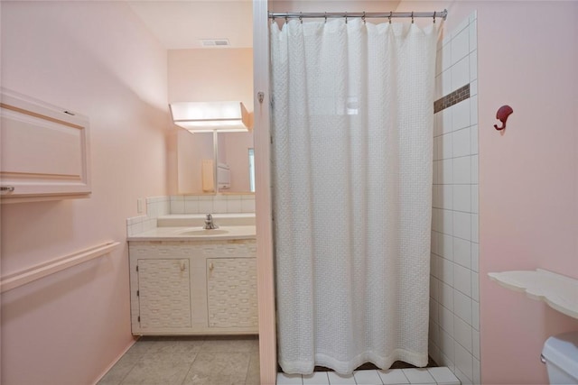 bathroom with walk in shower, tile patterned floors, and vanity