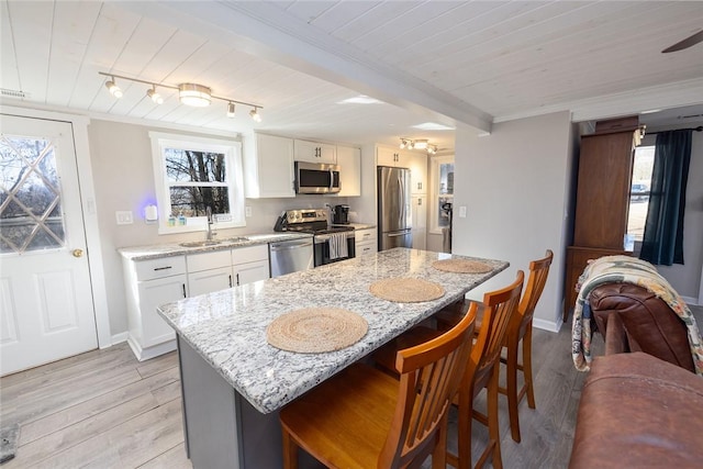 kitchen featuring sink, light stone countertops, white cabinets, and appliances with stainless steel finishes