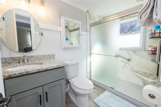 bathroom with vanity, a shower with shower door, crown molding, and toilet