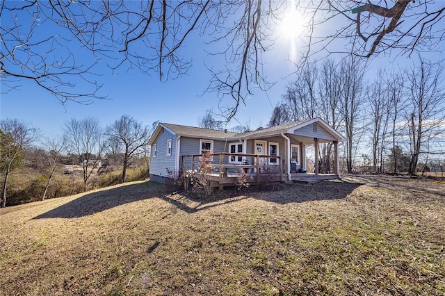 view of front facade featuring a deck, a front lawn, and covered porch