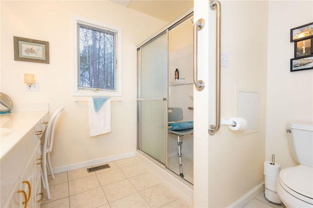 bathroom with tile patterned flooring, vanity, an enclosed shower, and toilet