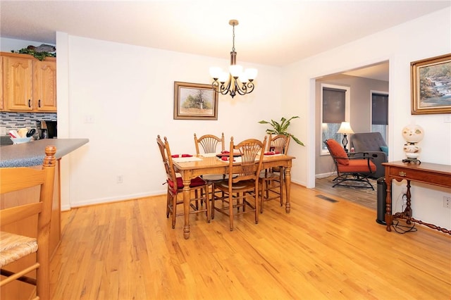 dining space featuring an inviting chandelier and light hardwood / wood-style floors