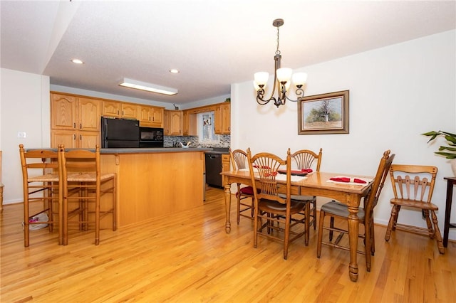 dining room with an inviting chandelier and light hardwood / wood-style flooring