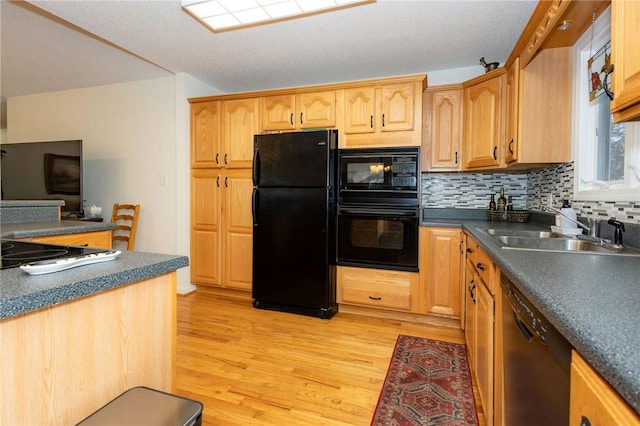 kitchen featuring tasteful backsplash, sink, light hardwood / wood-style flooring, and black appliances