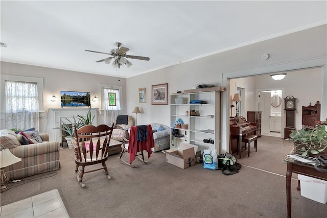 carpeted living room with crown molding and ceiling fan