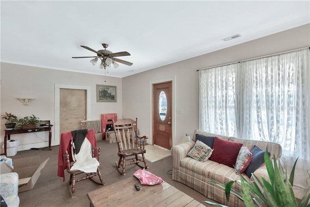 living room with ornamental molding and ceiling fan