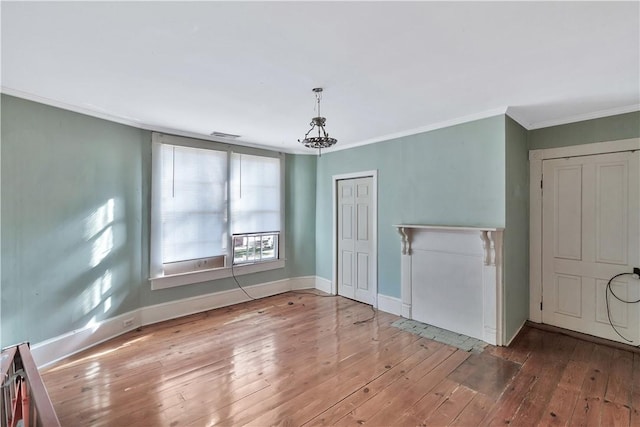 empty room with ornamental molding and hardwood / wood-style floors