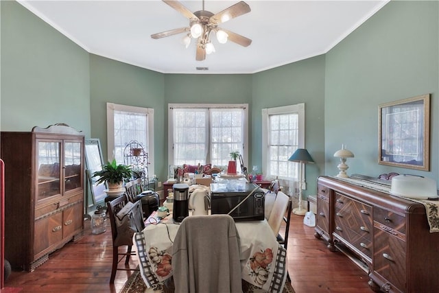 dining area featuring dark hardwood / wood-style flooring, ornamental molding, and ceiling fan