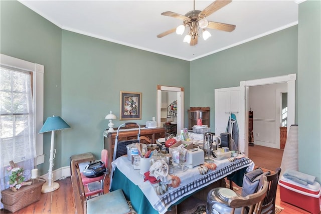 bedroom featuring wood-type flooring, ornamental molding, and ceiling fan